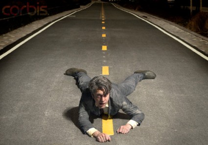 Businessman Crawling on Road --- Image by © Josh Gosfield/Corbis